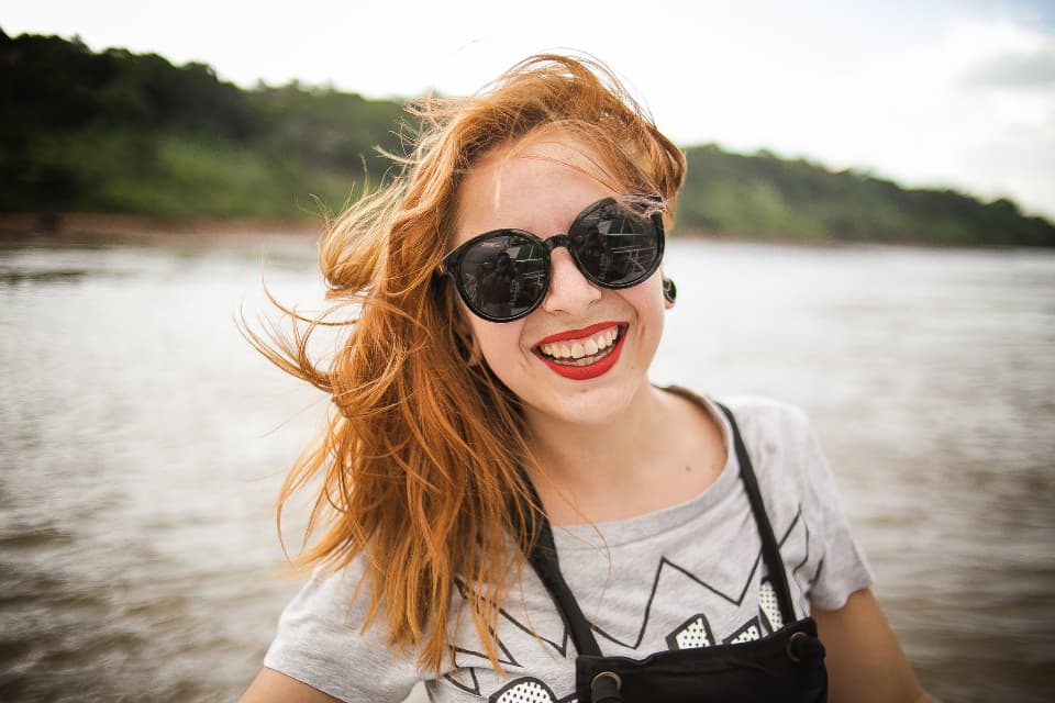 Smiling person outdoors wearing sunglasses