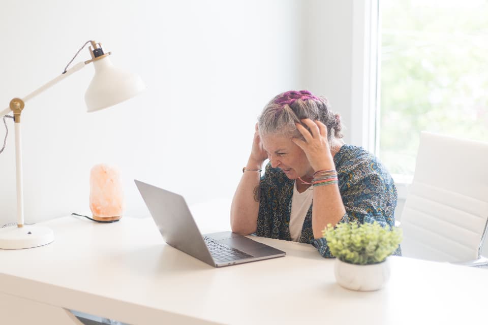 Overwhelmed person working at a bright desk